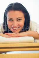 smiling woman resting on bed at spa