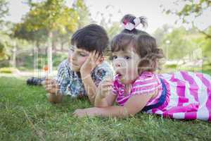 Young Brother and Baby Sister Enjoying Their Lollipops Outdoors
