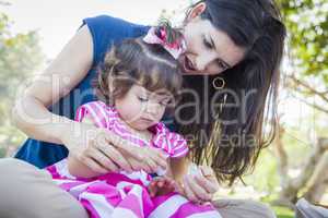 Young Mother and Cute Baby Girl Applying Fingernail Polish