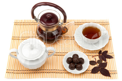 cup of tea and sweets in a saucer on the mat