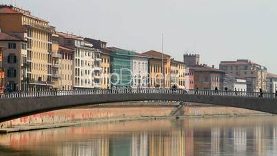 Pedestrians crossing the bridge in Pisa