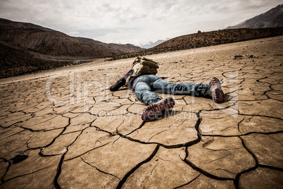person lays on the dried ground
