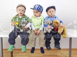 three sitting boys with toys