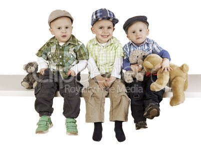 three sitting boys with toys