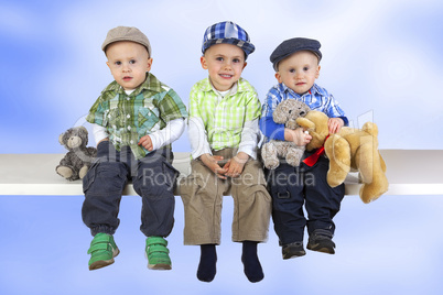 three sitting boys with toys