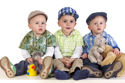 three sitting boys with toys