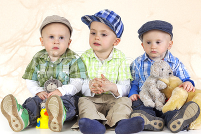 three sitting boys with toys