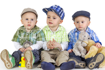 three sitting boys with toys