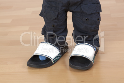children's feet in large slippers