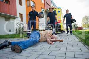 Paramedics giving help to injured senior man