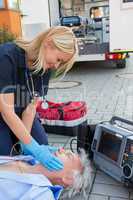 Paramedic helping injured patient on street