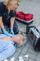 Paramedic examining unconscious patient