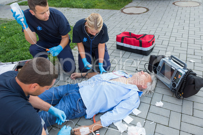 Emergency team giving firstaid to elderly patient