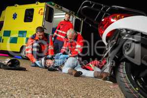 Paramedics helping injured motorcycle driver