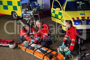 Paramedics helping motorbike driver on stretcher