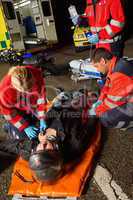 Paramedics examining injured motorcycle man driver