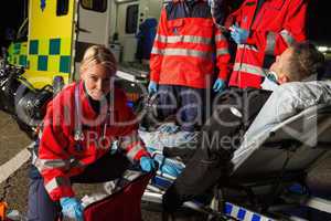 Paramedics assisting injured motorcycle man driver
