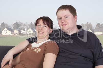 man and woman sitting together on the sofa