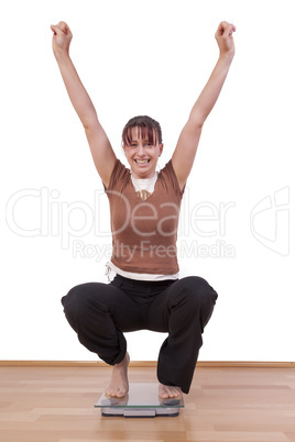 woman standing on the scales and is happy about her weight