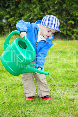 child with watering can in the garden