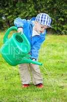 child with watering can in the garden