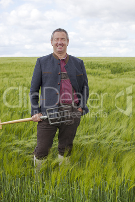 farmer digging fork in barley field