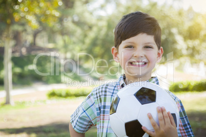 Cute Young Boy Playing with Soccer Ball in Park