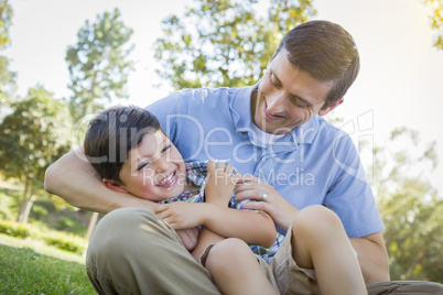 Loving Father Tickling Son in the Park