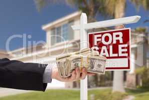 Buyer Handing Over Cash for House with For Sale Sign