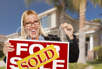 Excited Woman Holding House Keys and Sold Real Estate Sign Excited Woman Holding House Keys and Sold Real Estate Sign