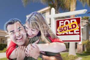 Couple in Front of Sold Real Estate Sign and House