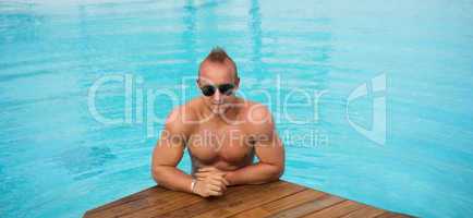 muscular man posing in the swimming pool