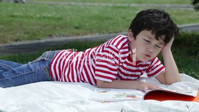 Child reading book in park