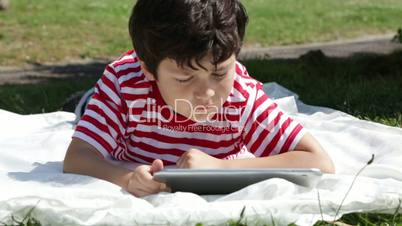 Child using digital tablet in the park