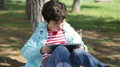 Child using digital tablet in the park