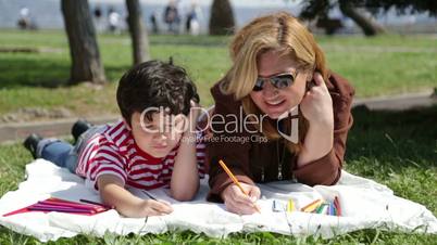 mother and son painting in the park