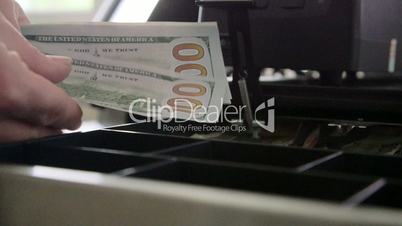 Cashier counts and puts cash into a register