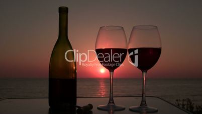 man and woman clinked glasses with red wine at sunset