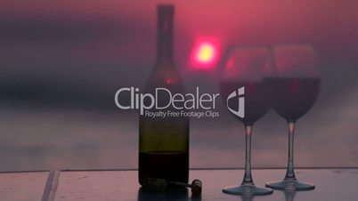 Two glasses of red wine and beautiful sunset by the sea