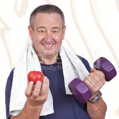 Elderly man with apple and dumbbells