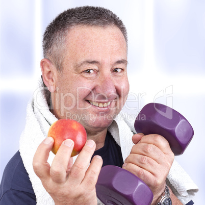 Elderly man with apple and dumbbells