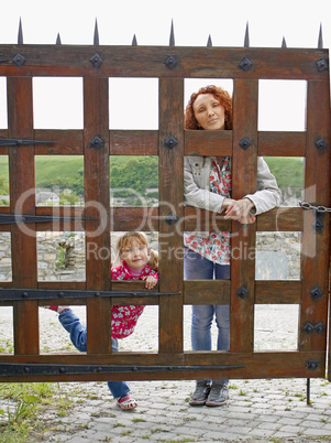 Woman and a small girl behind a wooden gate