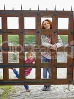 Woman and a small girl behind a wooden gate