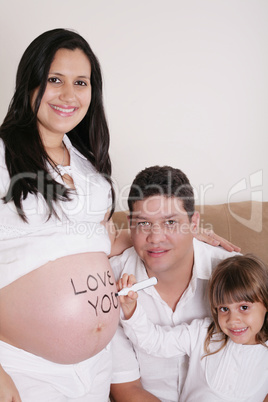 Family With Pregnant Mother Relaxing On Sofa Together with the w