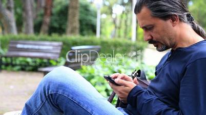 Man Using a Smartphone in park  close up