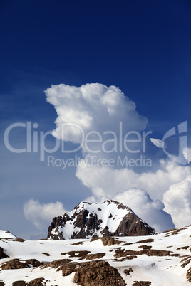 Rocks in snow and blue sky with clouds