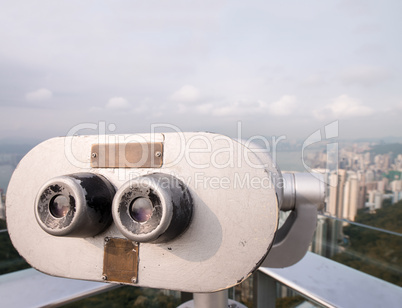 Telescope looking at city skyscrapers