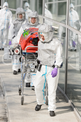 Biohazard medical team with stretcher outside building