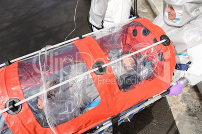 Biohazard team with virus patient in stretcher
