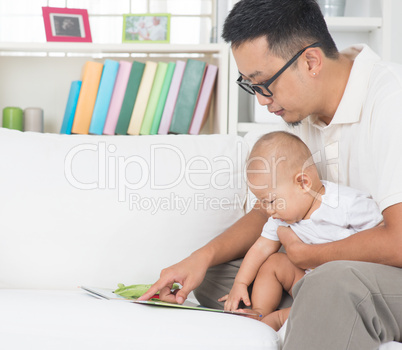 father and baby reading story book